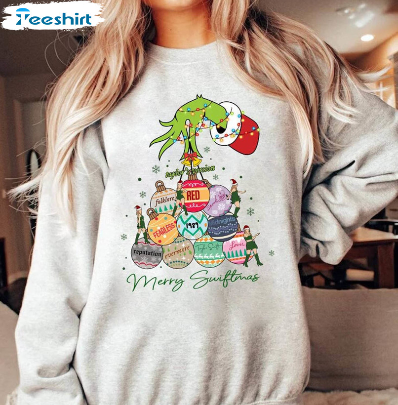 https://img.9teeshirt.com/images/desgin/351/trending/r7710s/1-merry-swiftmas-sweatshirt-the-eras-tour-christmas-shirt-funny-grinch-hand-christmas-shirt-1.jpg